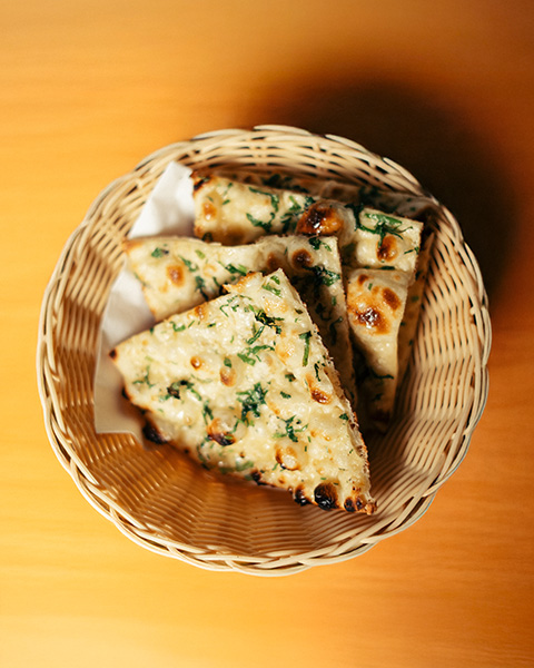 Fresh garlic naan in a wicker basket