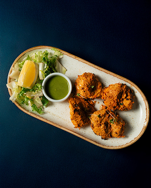 Spiced pakoras with green chutney, salad and lemon